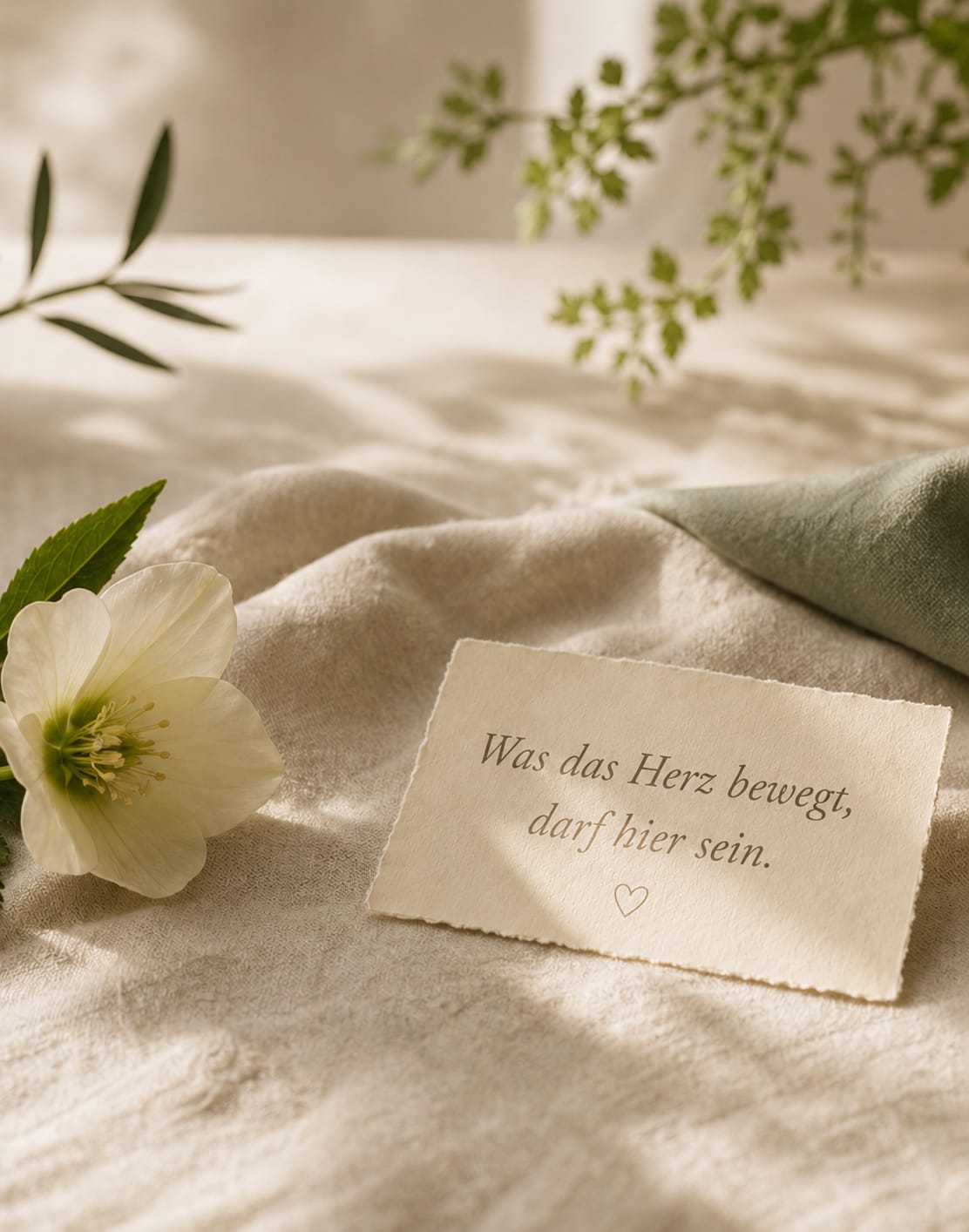 Stille Szene mit Blume, Karte und hellem Leinen für Trauerbegleitung